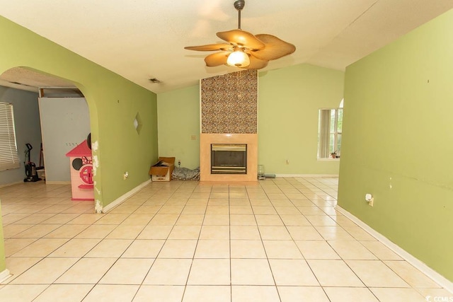 318 Muirfield Rd, Myrtle Beach, SC 29588 - unfurnished living room with arched walkways, lofted ceiling, a fireplace, a ceiling fan, and light tile patterned floors