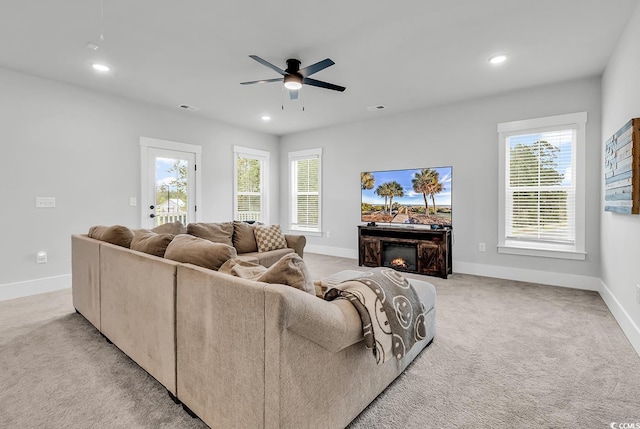 1216 Newell Dr, Myrtle Beach, SC 29588 - living room featuring a ceiling fan, a warm lit fireplace, light colored carpet, healthy amount of natural light, and recessed lighting