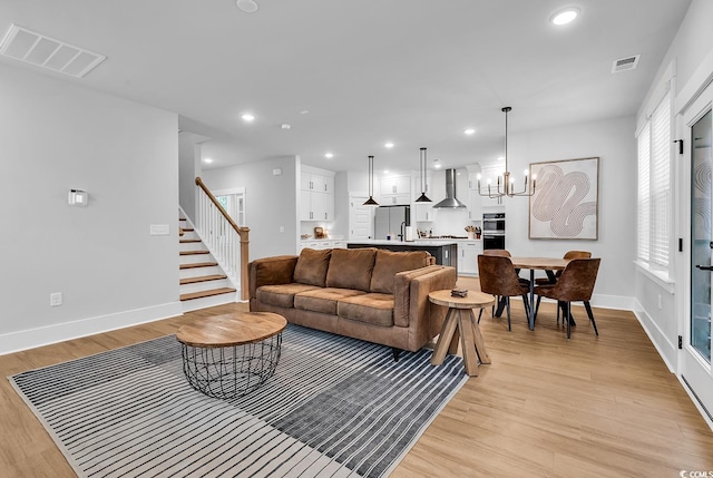 1216 Newell Dr, Myrtle Beach, SC 29588 - living room with light wood-type flooring, a chandelier, recessed lighting, and stairway