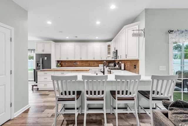 209 Haley Brooke Dr, Conway, SC 29526 - kitchen with stainless steel appliances, glass insert cabinets, decorative backsplash, light countertops, and a peninsula