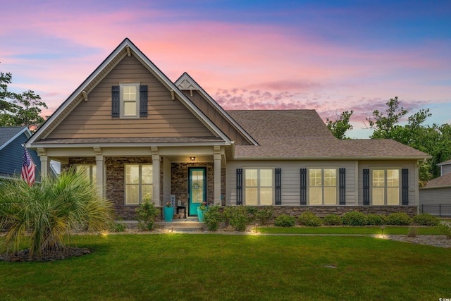 1715 Lake Egret Dr, North Myrtle Beach, SC 29582 - view of front of home featuring stone siding, a front yard, and a porch