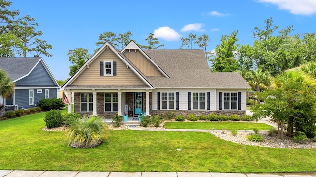 1715 Lake Egret Dr, North Myrtle Beach, SC 29582 - craftsman-style house with a porch, a front yard, stone siding, and a shingled roof