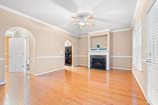 1654 Low Country Pl Unit C, Myrtle Beach, SC 29577 - unfurnished living room with arched walkways, ceiling fan, a premium fireplace, crown molding, and wood finished floors