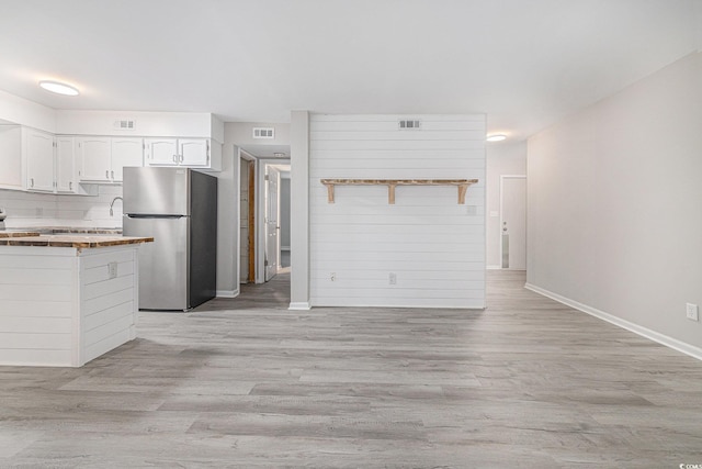 1500 Cenith Dr Unit B-403, North Myrtle Beach, SC 29582 - kitchen featuring freestanding refrigerator, light wood-style flooring, and white cabinetry