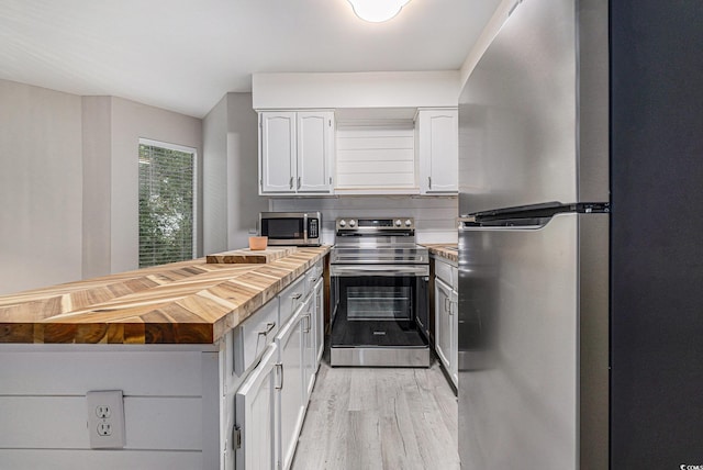 1500 Cenith Dr Unit B-403, North Myrtle Beach, SC 29582 - kitchen with appliances with stainless steel finishes, wood counters, a peninsula, light wood-style floors, and white cabinets