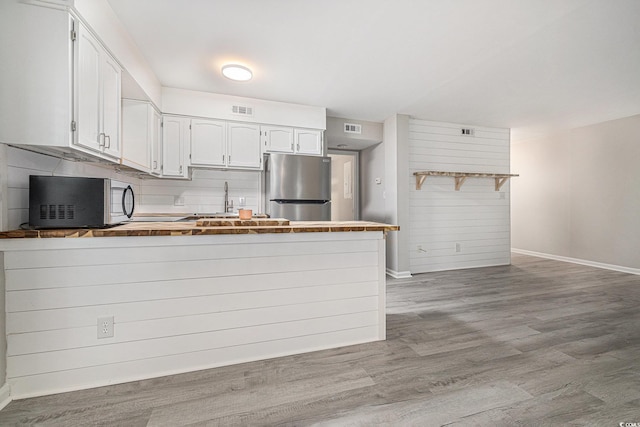 1500 Cenith Dr Unit B-403, North Myrtle Beach, SC 29582 - kitchen featuring appliances with stainless steel finishes, a peninsula, wood finished floors, and white cabinetry