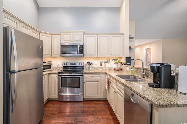 276 Avery Dr, Myrtle Beach, SC 29588 - kitchen featuring appliances with stainless steel finishes, a peninsula, cream cabinetry, dark wood-type flooring, and light stone countertops