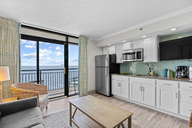 4800 S Ocean Blvd Unit 1524, North Myrtle Beach, SC 29582 - kitchen featuring appliances with stainless steel finishes, floor to ceiling windows, a water view, ornamental molding, and backsplash