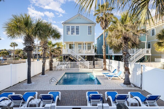 611 N Ocean Blvd, Surfside Beach, SC 29575 - view of swimming pool featuring stairs, a fenced backyard, and a patio