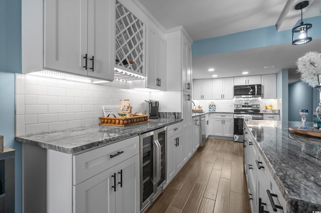 7601 N Ocean Blvd Unit 7-C, Myrtle Beach, SC 29572 - kitchen with stainless steel appliances, beverage cooler, backsplash, wood finished floors, and white cabinets