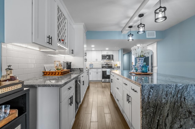 7601 N Ocean Blvd Unit 7-C, Myrtle Beach, SC 29572 - kitchen with stainless steel appliances, backsplash, light wood-style floors, and dark stone countertops