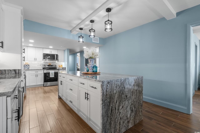 7601 N Ocean Blvd Unit 7-C, Myrtle Beach, SC 29572 - kitchen featuring stainless steel appliances, wood finished floors, backsplash, a kitchen island, and white cabinets