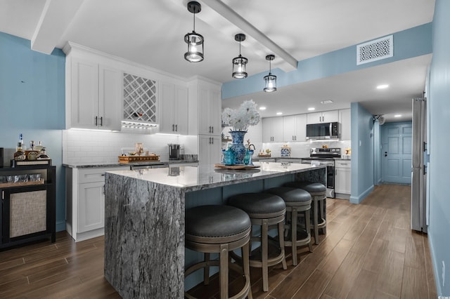 7601 N Ocean Blvd Unit 7-C, Myrtle Beach, SC 29572 - kitchen with stainless steel appliances, dark wood-style floors, white cabinetry, beam ceiling, and recessed lighting
