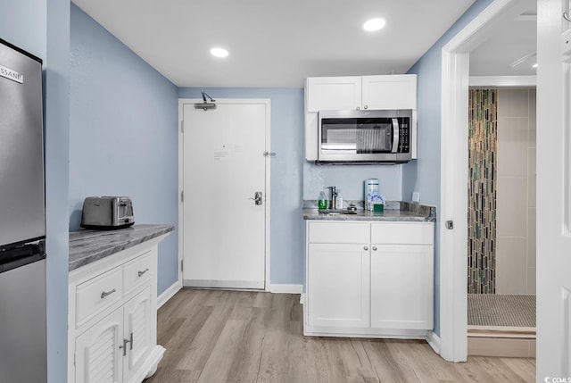 201 74th Ave N Unit 2534, Myrtle Beach, SC 29572 - kitchen with appliances with stainless steel finishes, white cabinets, light wood finished floors, recessed lighting, and light stone countertops