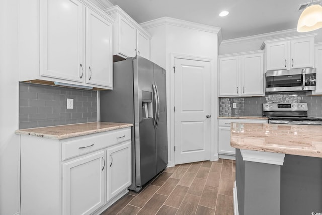 124 Castaway Key Dr, Pawleys Island, SC 29585 - kitchen featuring appliances with stainless steel finishes, white cabinets, crown molding, tasteful backsplash, and recessed lighting