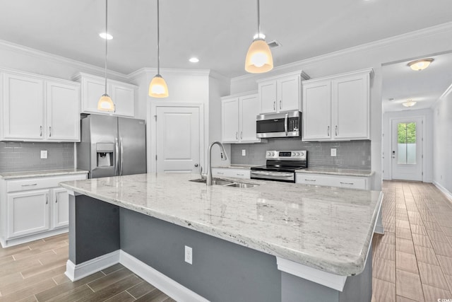 124 Castaway Key Dr, Pawleys Island, SC 29585 - kitchen featuring stainless steel appliances, light wood-style floors, white cabinetry, decorative backsplash, and ornamental molding