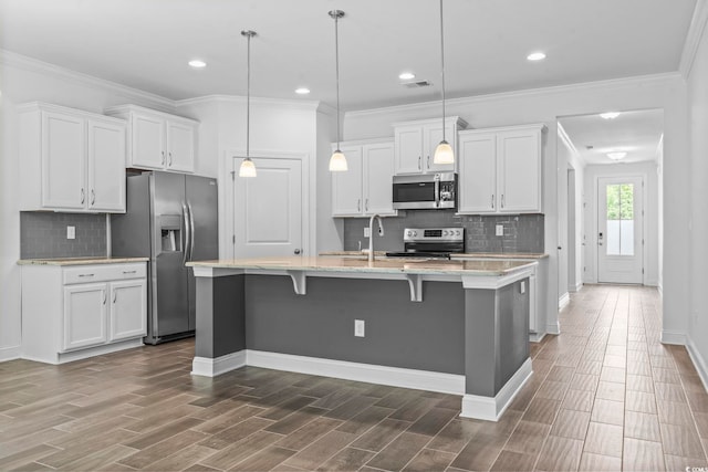 124 Castaway Key Dr, Pawleys Island, SC 29585 - kitchen featuring stainless steel appliances, tasteful backsplash, white cabinetry, an island with sink, and recessed lighting