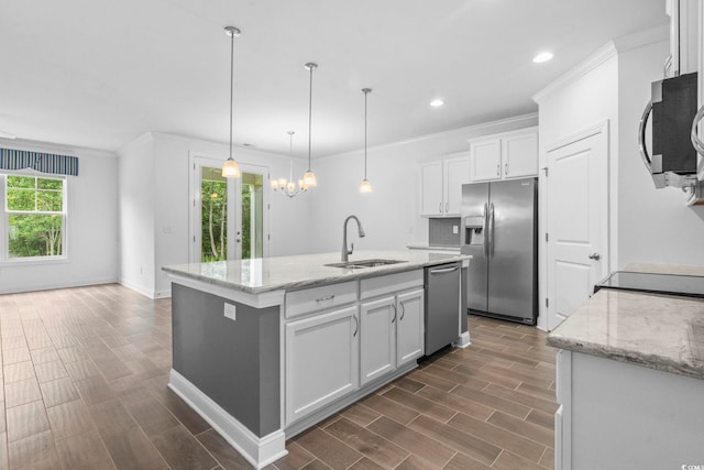 124 Castaway Key Dr, Pawleys Island, SC 29585 - kitchen featuring appliances with stainless steel finishes, white cabinetry, crown molding, a kitchen island with sink, and dark wood-style floors