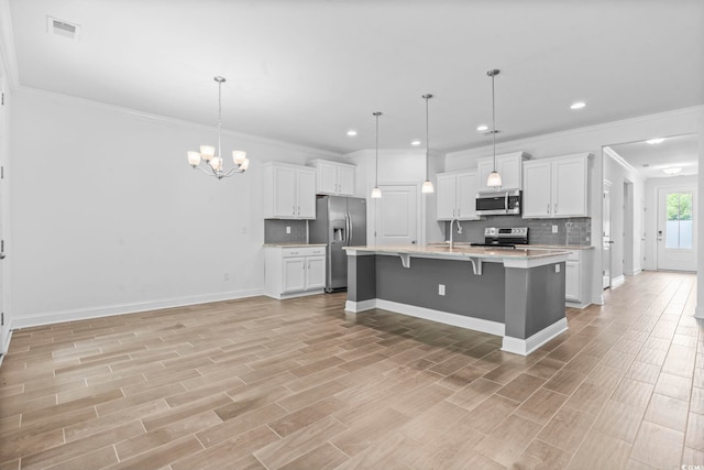124 Castaway Key Dr, Pawleys Island, SC 29585 - kitchen featuring stainless steel appliances, backsplash, light countertops, a breakfast bar, and crown molding