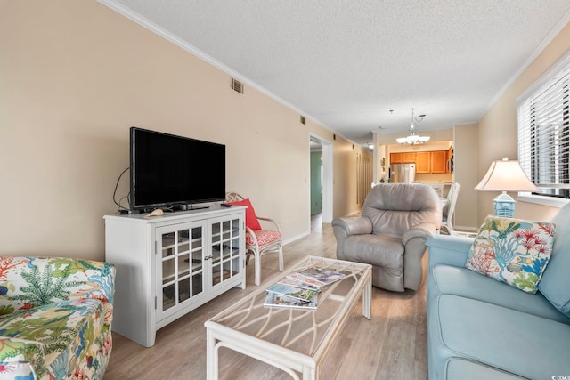 305 Hillside Dr N Unit 205, North Myrtle Beach, SC 29582 - living area featuring light wood finished floors, ornamental molding, a chandelier, and a textured ceiling