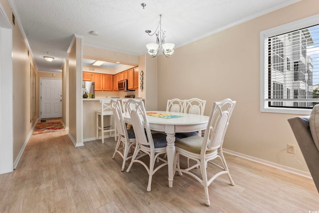 305 Hillside Dr N Unit 205, North Myrtle Beach, SC 29582 - dining space with crown molding, light wood-style flooring, a chandelier, and a textured ceiling
