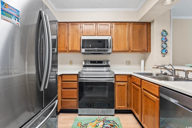 305 Hillside Dr N Unit 205, North Myrtle Beach, SC 29582 - kitchen featuring stainless steel appliances, light countertops, ornamental molding, brown cabinets, and a textured ceiling