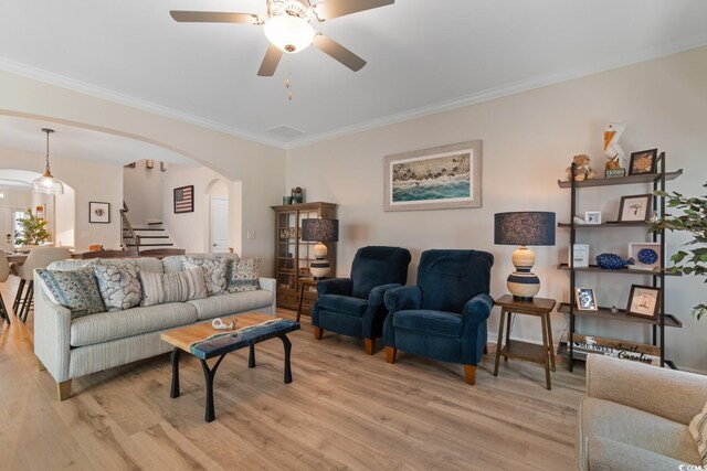 3185 Viceroy Loop, Little River, SC 29566 - living room with arched walkways, stairs, light wood-style flooring, ornamental molding, and a ceiling fan