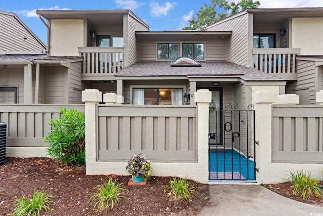 620 15th Ave S Unit 87, Surfside Beach, SC 29575 - back of property featuring a gate, a balcony, a fenced front yard, and stucco siding