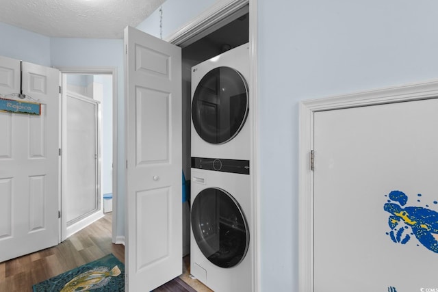 620 15th Ave S Unit 87, Surfside Beach, SC 29575 - washroom with stacked washing machine and dryer, dark wood finished floors, and a textured ceiling