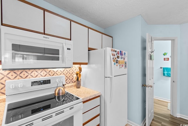 620 15th Ave S Unit 87, Surfside Beach, SC 29575 - kitchen featuring white appliances, wood finished floors, backsplash, light countertops, and white cabinetry
