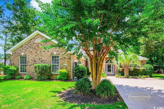 4499 Firethorne Dr, Murrells Inlet, SC 29576 - view of property hidden behind natural elements with brick siding, a front yard, and concrete driveway