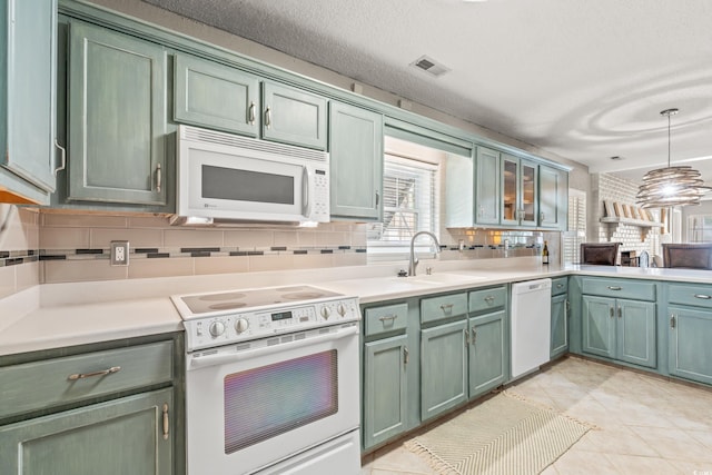 3597 Sunfish St, Murrells Inlet, SC 29576 - kitchen featuring white appliances, backsplash, green cabinetry, light countertops, and pendant lighting
