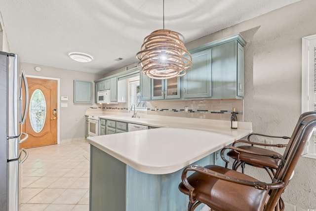 3597 Sunfish St, Murrells Inlet, SC 29576 - kitchen with white appliances, light countertops, a peninsula, and a kitchen bar