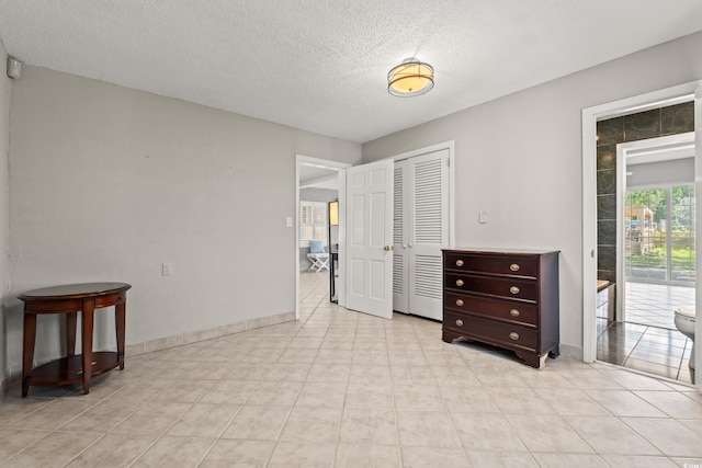 3597 Sunfish St, Murrells Inlet, SC 29576 - unfurnished bedroom featuring a textured ceiling, a closet, access to exterior, and light tile patterned floors