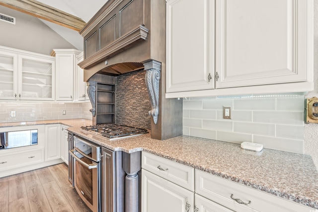 3597 Sunfish St, Murrells Inlet, SC 29576 - kitchen with appliances with stainless steel finishes, decorative backsplash, light wood finished floors, vaulted ceiling, and white cabinetry