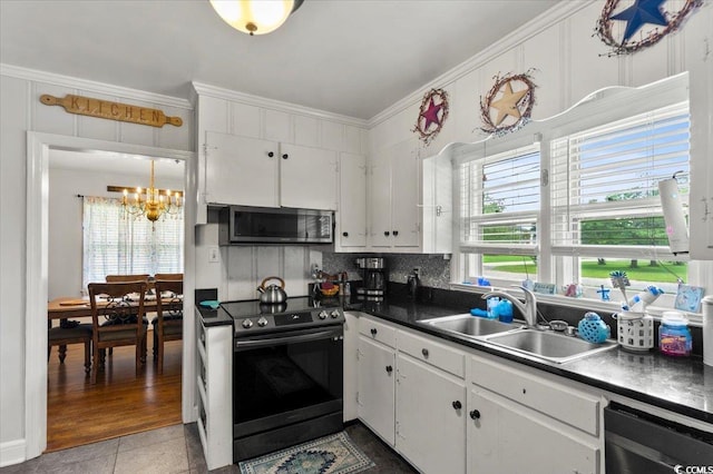 1008 N Withlacoochee Ave, Marion, SC 29571 - kitchen with appliances with stainless steel finishes, a chandelier, dark countertops, white cabinetry, and tasteful backsplash