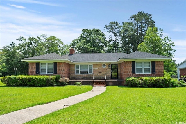 1008 N Withlacoochee Ave, Marion, SC 29571 - ranch-style house with a front yard, a chimney, a porch, and brick siding