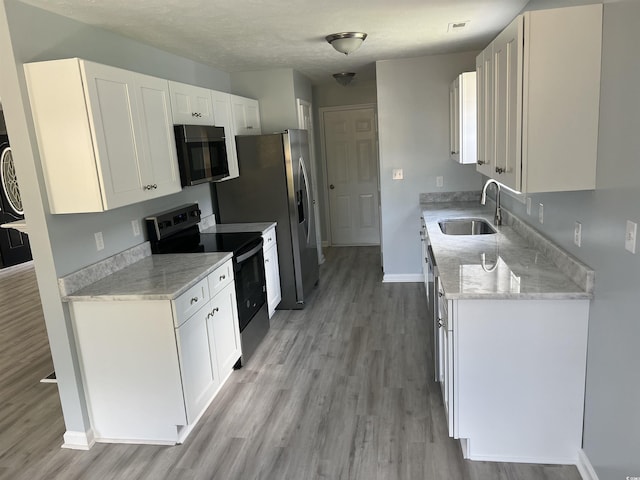 9888 Conifer Ln, Murrells Inlet, SC 29576 - kitchen featuring stainless steel appliances, light wood-type flooring, white cabinets, and light stone countertops