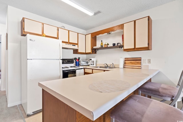 500 Fairway Village Dr Unit J-7, Myrtle Beach, SC 29588 - kitchen with white appliances, under cabinet range hood, a peninsula, light countertops, and a textured ceiling