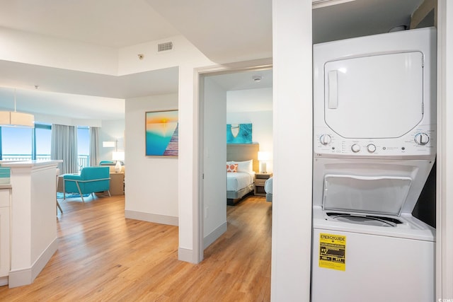 3000 N Ocean Blvd Unit 209, Myrtle Beach, SC 29577 - washroom with stacked washer / drying machine and light wood-style floors