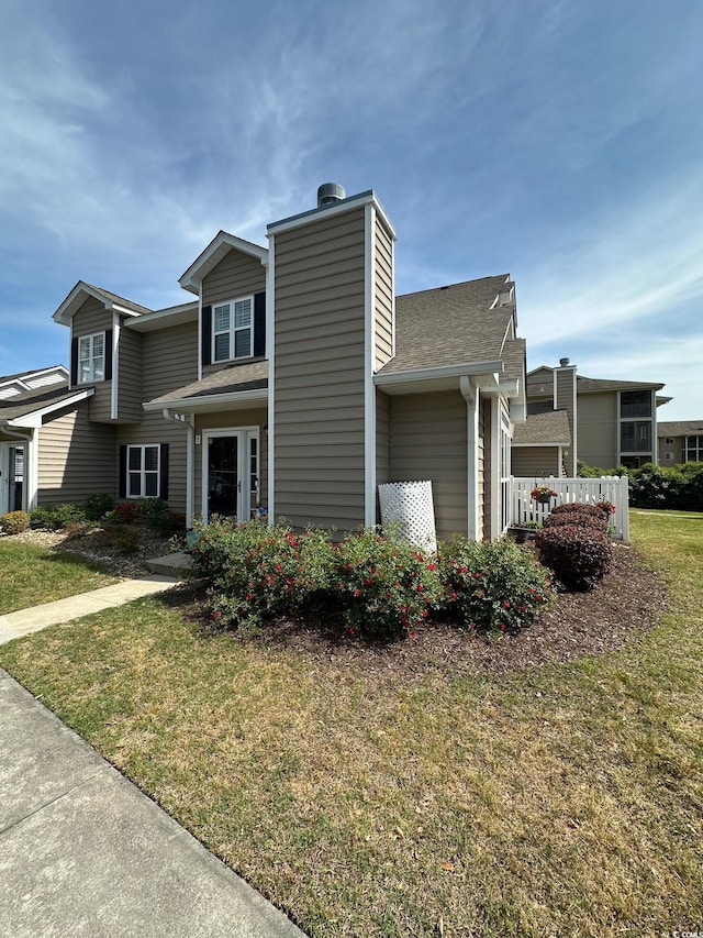 503 20th Ave N Unit 3B, North Myrtle Beach, SC 29582 - view of property exterior with a yard and roof with shingles