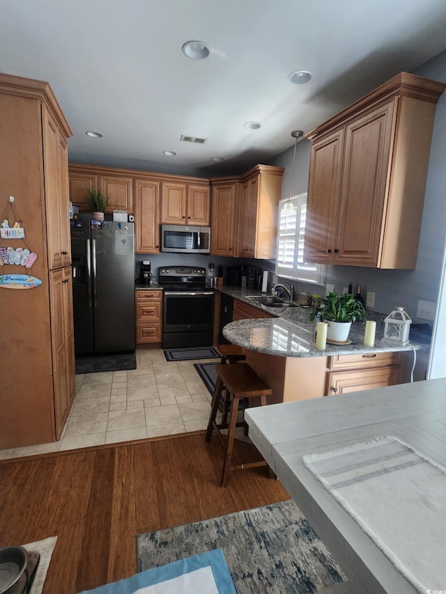 503 20th Ave N Unit 3B, North Myrtle Beach, SC 29582 - kitchen with refrigerator with ice dispenser, stainless steel microwave, range with electric cooktop, decorative light fixtures, and stone counters