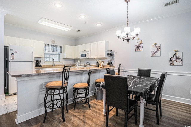 4868 Dahlia Ct Unit 202, Myrtle Beach, SC 29577 - dining room featuring ornamental molding, a chandelier, dark wood-style floors, and recessed lighting