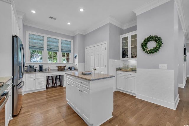 179 Cottage Ct, Pawleys Island, SC 29585 - kitchen featuring stainless steel fridge, white cabinets, light wood-type flooring, ornamental molding, and recessed lighting