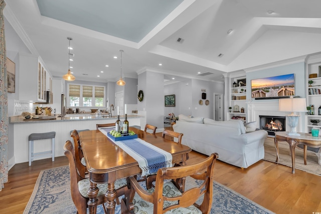 179 Cottage Ct, Pawleys Island, SC 29585 - dining area with light wood finished floors, built in features, a warm lit fireplace, recessed lighting, and lofted ceiling