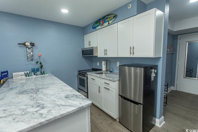 1207 S Ocean Blvd Unit 20403, Myrtle Beach, SC 29577 - kitchen with stainless steel appliances, light wood-style floors, white cabinetry, light stone countertops, and recessed lighting