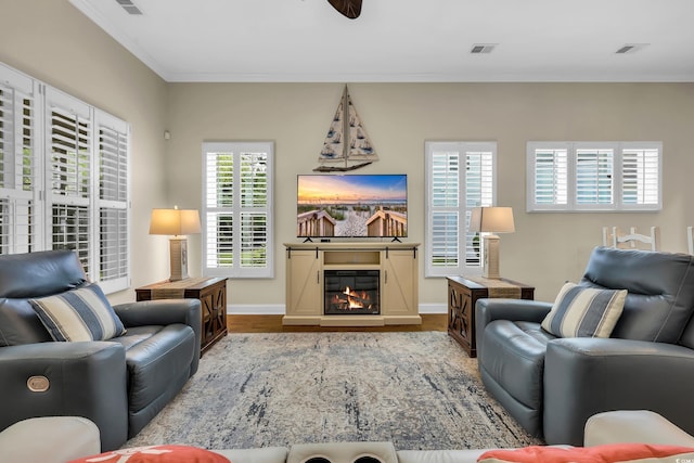 2199 Birchwood Cir, Myrtle Beach, SC 29577 - living area with wood finished floors, a glass covered fireplace, a ceiling fan, and crown molding