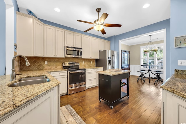 2199 Birchwood Cir, Myrtle Beach, SC 29577 - kitchen with appliances with stainless steel finishes, ceiling fan, light stone counters, decorative backsplash, and a chandelier