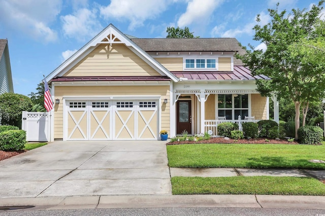 2199 Birchwood Cir, Myrtle Beach, SC 29577 - view of front of house featuring covered porch, a standing seam roof, driveway, a garage, and a metal roof
