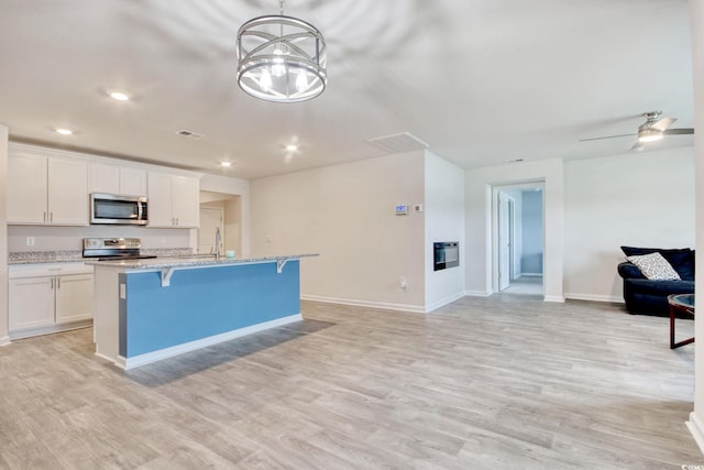 211 Seasons Trace Loop, Longs, SC 29568 - kitchen featuring stainless steel appliances, open floor plan, a center island with sink, white cabinets, and recessed lighting